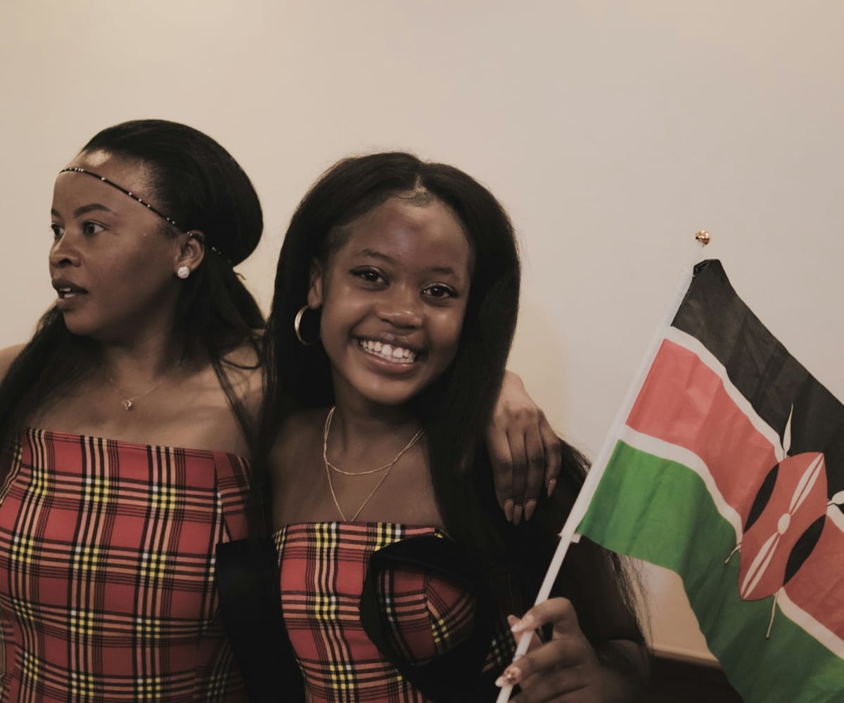 Two smiling Kenyan women holding the Kenyan flag